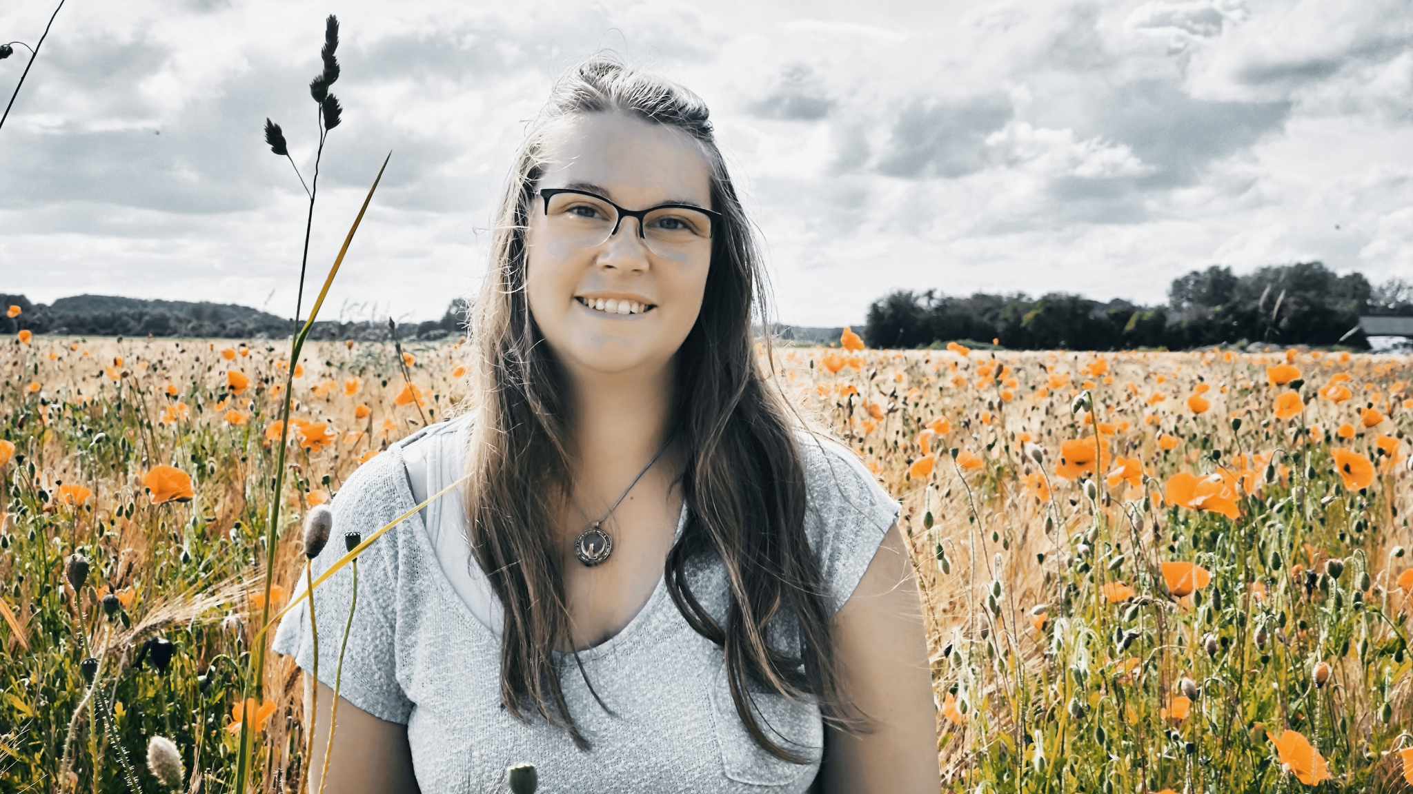 Laura Louwette, souriante dans un champs de fleurs